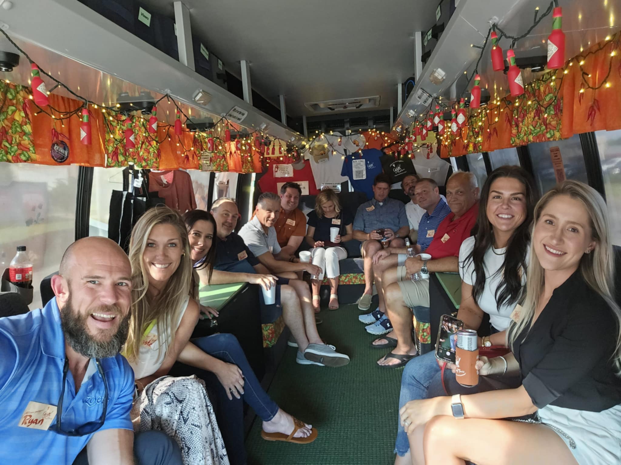 inside party bus Group of people smiling inside a decorated bus with lights and colorful decorations on the ceiling.