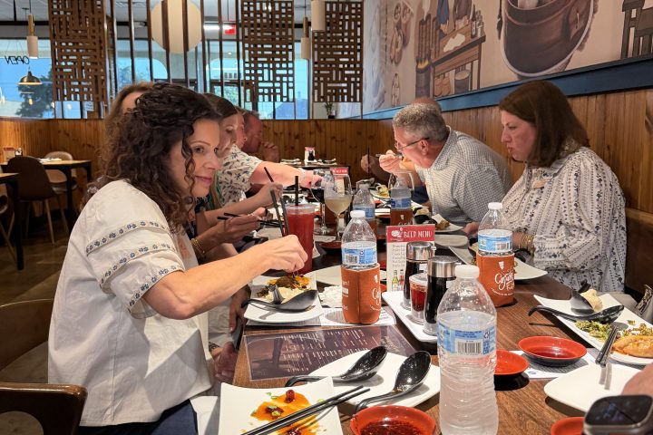 Group of people dining at a restaurant with Asian-themed decor.